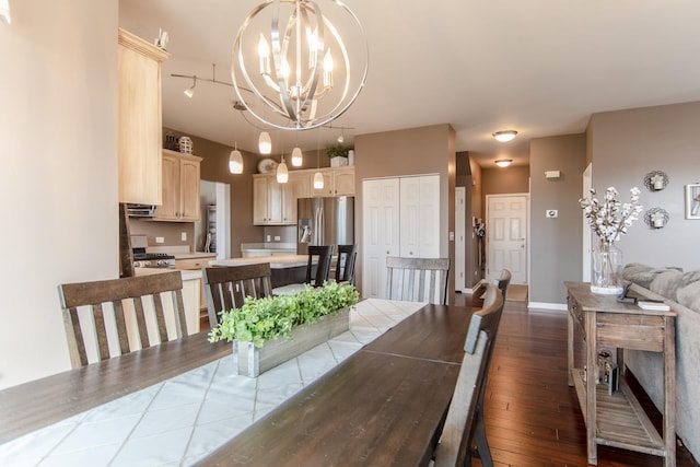 dining space with hardwood / wood-style flooring, a chandelier, and baseboards