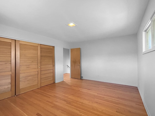 1048 Marshall Dr, Des Plaines, IL 60016 - unfurnished bedroom featuring a closet, light wood-style flooring, and baseboards