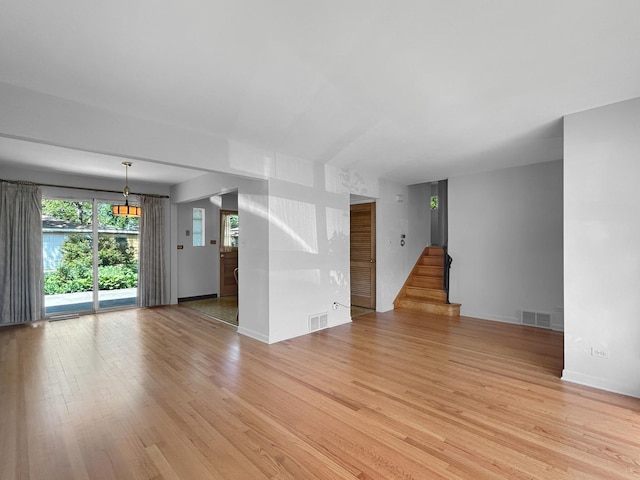 1048 Marshall Dr, Des Plaines, IL 60016 - unfurnished living room featuring light wood-type flooring, stairs, and baseboards