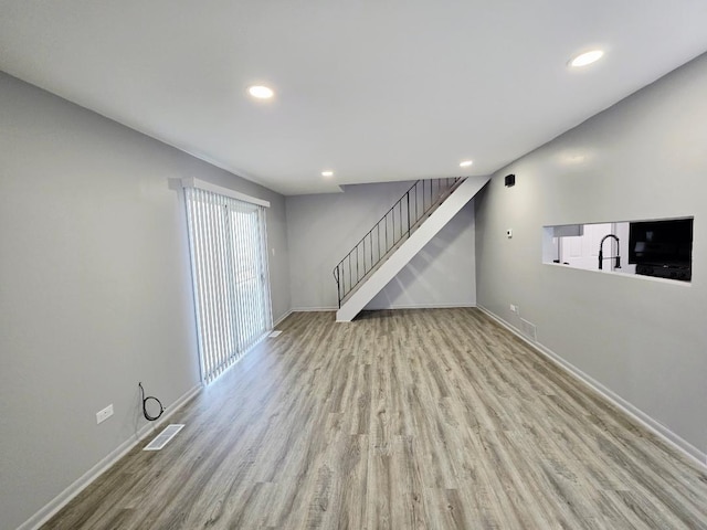 20120 Ash Ln Unit 0, Lynwood, IL 60411 - unfurnished living room featuring wood finished floors, stairs, baseboards, recessed lighting, and a sink