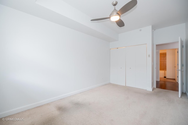 unfurnished bedroom with carpet flooring, a closet, baseboards, and ceiling fan