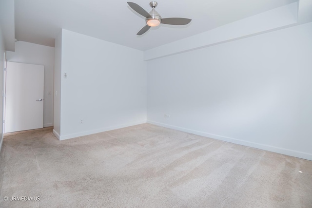 spare room featuring ceiling fan, carpet floors, and baseboards
