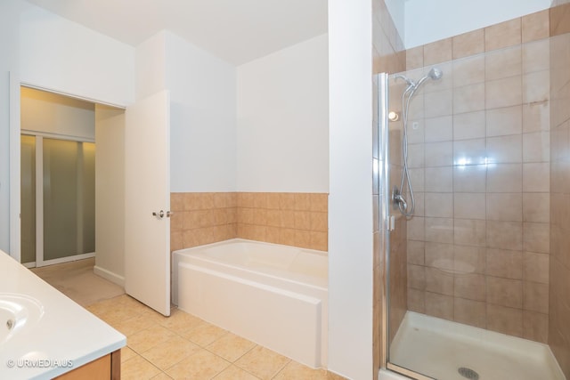 bathroom featuring tile patterned floors, a stall shower, a garden tub, and vanity