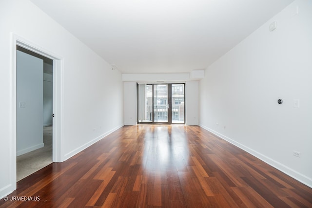 empty room featuring wood finished floors and baseboards