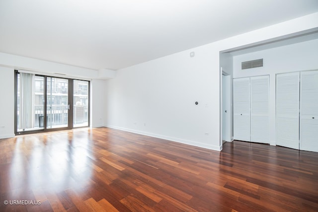 spare room featuring wood finished floors and baseboards