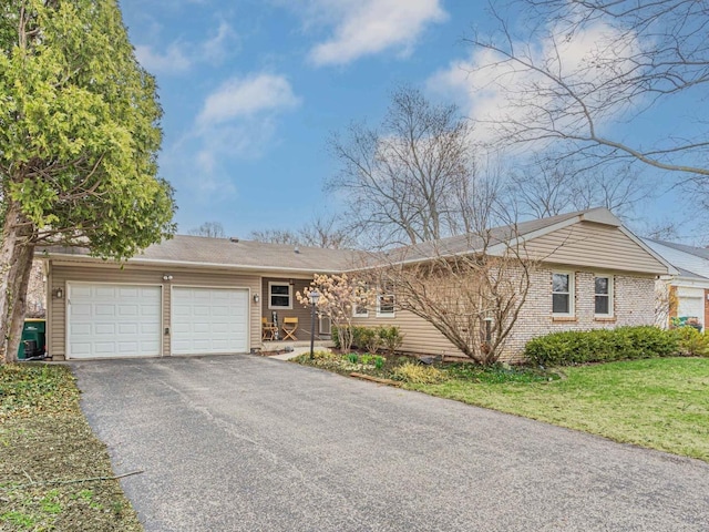 ranch-style home featuring a garage, driveway, and a front yard