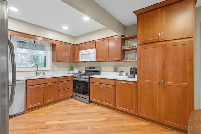 kitchen featuring stainless steel appliances, a sink, open shelves, brown cabinets, and recessed lighting