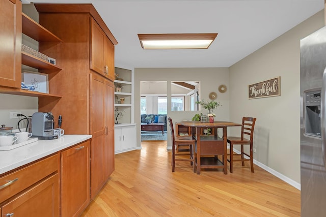 dining area featuring light wood-style floors and baseboards