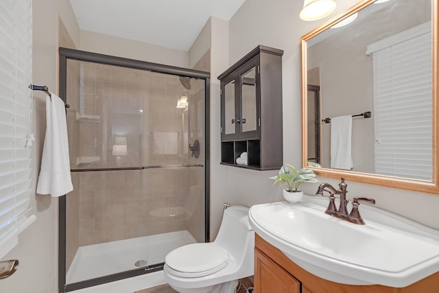 bathroom featuring a stall shower, vanity, and toilet