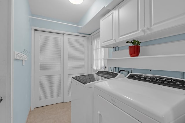 clothes washing area with cabinet space, independent washer and dryer, light tile patterned floors, and baseboards