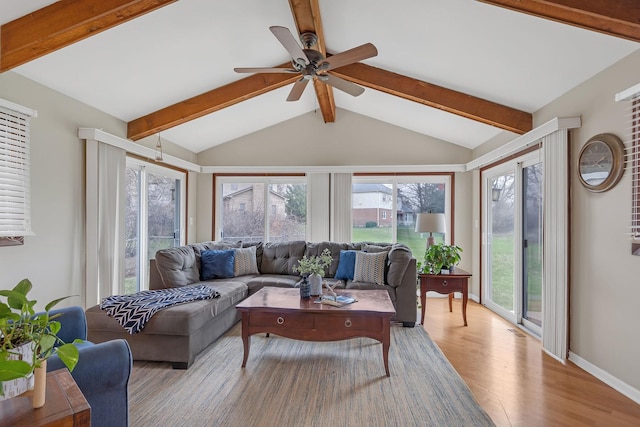 living room with wood finished floors, healthy amount of natural light, ceiling fan, and baseboards