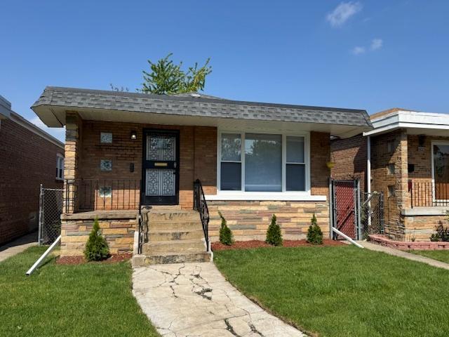 view of front of house featuring a gate, covered porch, and brick siding