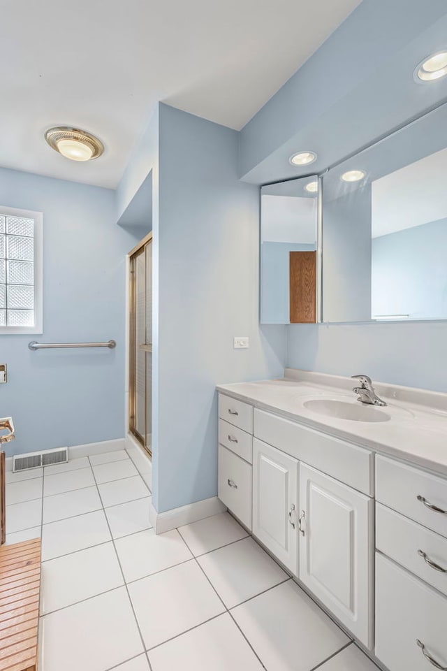 full bath with tile patterned floors, vanity, a shower stall, and baseboards