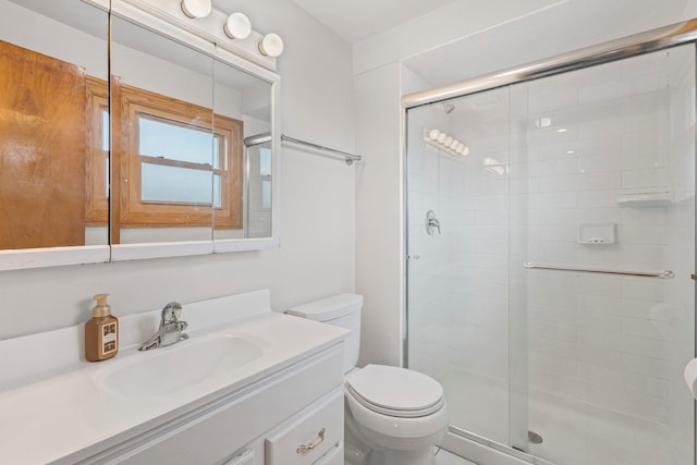 full bathroom with toilet, a stall shower, and vanity
