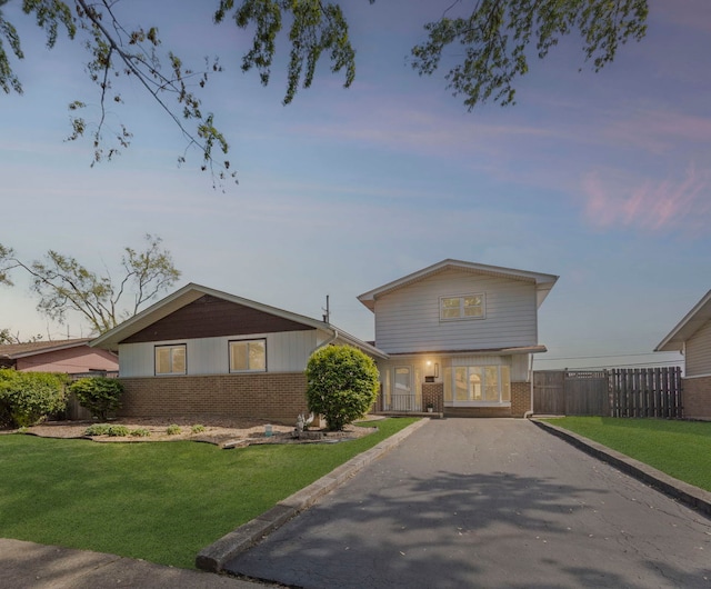 view of front of home with brick siding and asphalt driveway