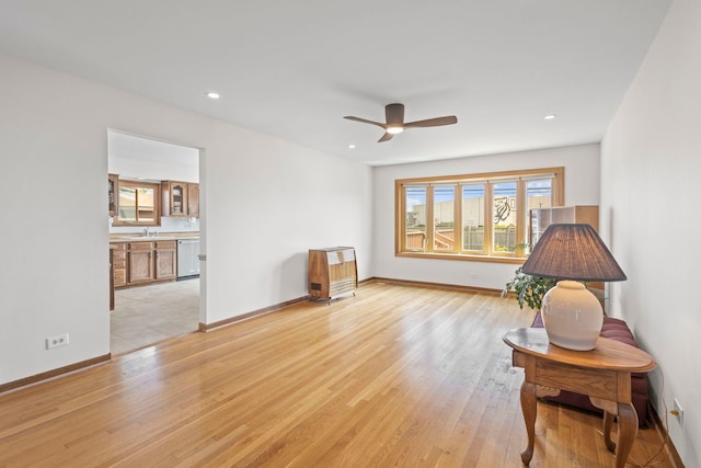 living area with light wood-style flooring, a ceiling fan, baseboards, and recessed lighting