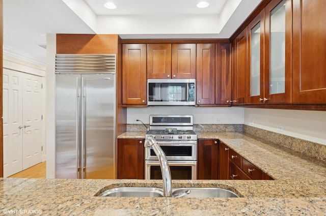 518 Winnetka Ave Unit 203, Winnetka, IL 60093 - kitchen featuring appliances with stainless steel finishes, light stone counters, glass insert cabinets, recessed lighting, and a sink