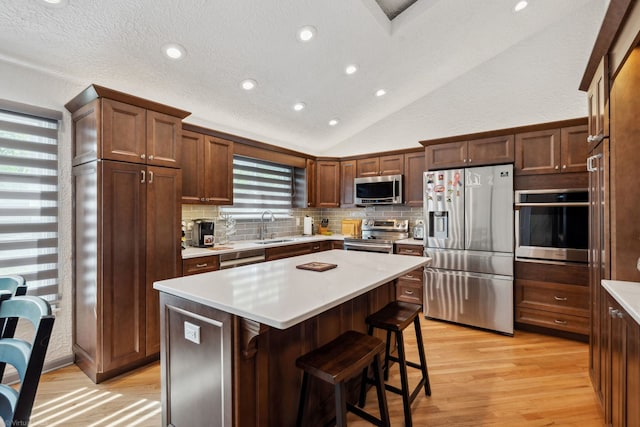 396 Jervey Ln, Bartlett, IL 60103 - kitchen with appliances with stainless steel finishes, a sink, tasteful backsplash, lofted ceiling, and light wood-style floors