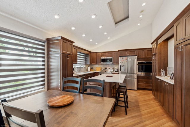 396 Jervey Ln, Bartlett, IL 60103 - kitchen featuring stainless steel appliances, a sink, light countertops, light wood finished floors, and lofted ceiling