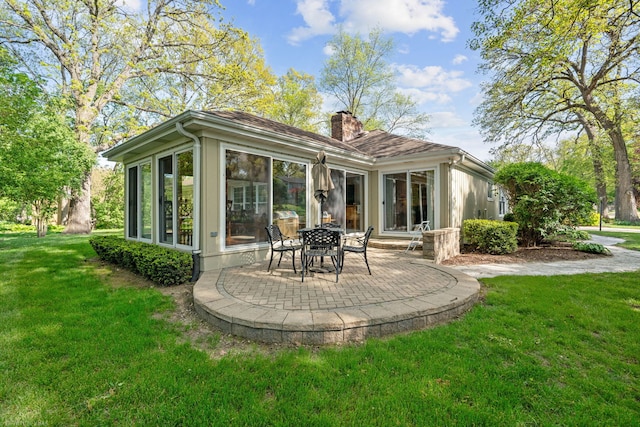 396 Jervey Ln, Bartlett, IL 60103 - rear view of house featuring a chimney, a patio area, a lawn, and a sunroom
