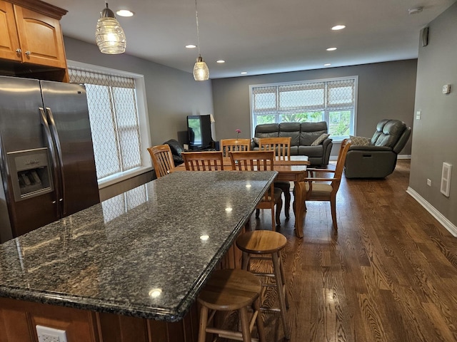 6710 W Harts Rd, Niles, IL 60714 - kitchen featuring stainless steel fridge with ice dispenser, dark wood finished floors, recessed lighting, open floor plan, and a breakfast bar
