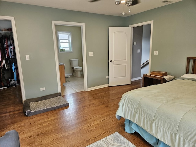 6710 W Harts Rd, Niles, IL 60714 - bedroom featuring a spacious closet, a closet, ensuite bath, wood finished floors, and baseboards