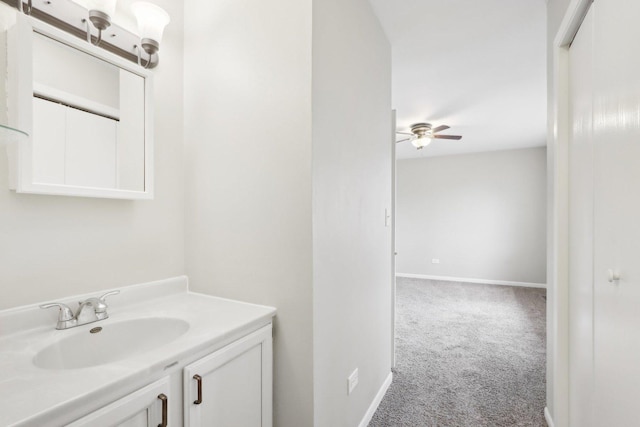 bathroom featuring ceiling fan, baseboards, and vanity