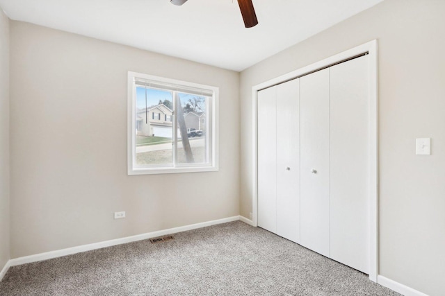 unfurnished bedroom with light carpet, baseboards, a closet, and ceiling fan