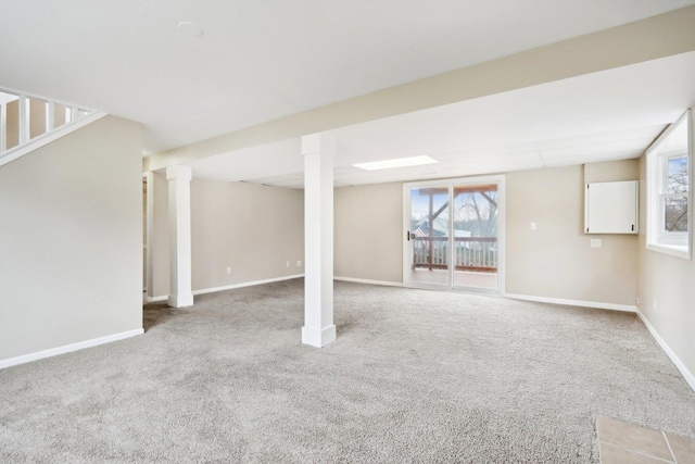 below grade area with light carpet, healthy amount of natural light, and baseboards