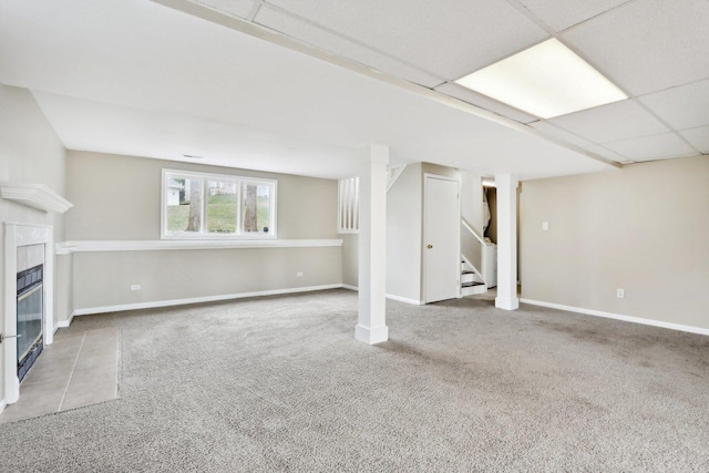 basement featuring carpet, stairway, a fireplace, and baseboards