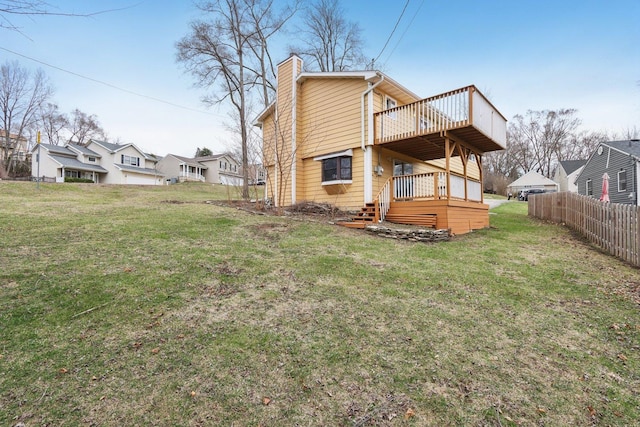 rear view of property featuring a chimney and a wooden deck