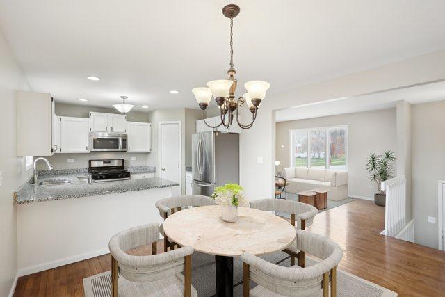 dining area featuring a chandelier, wood finished floors, recessed lighting, and baseboards