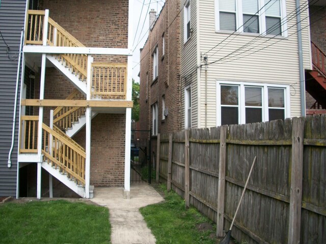 7421 S Eberhart Ave, Chicago, IL 60619 - view of home's exterior with stairs and fence