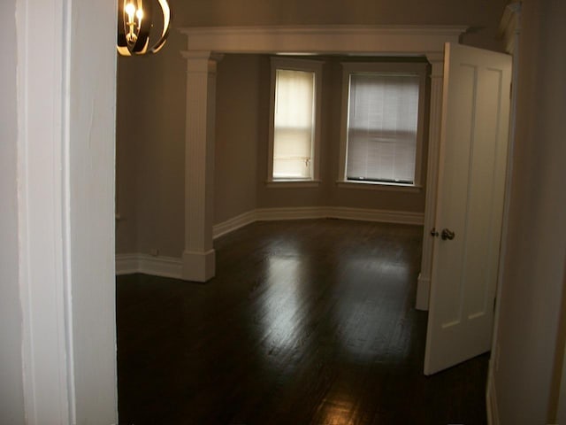 7421 S Eberhart Ave, Chicago, IL 60619 - spare room with baseboards, dark wood-style floors, and decorative columns