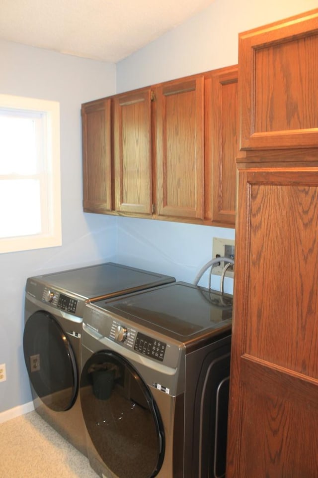 laundry room featuring independent washer and dryer, cabinet space, and baseboards