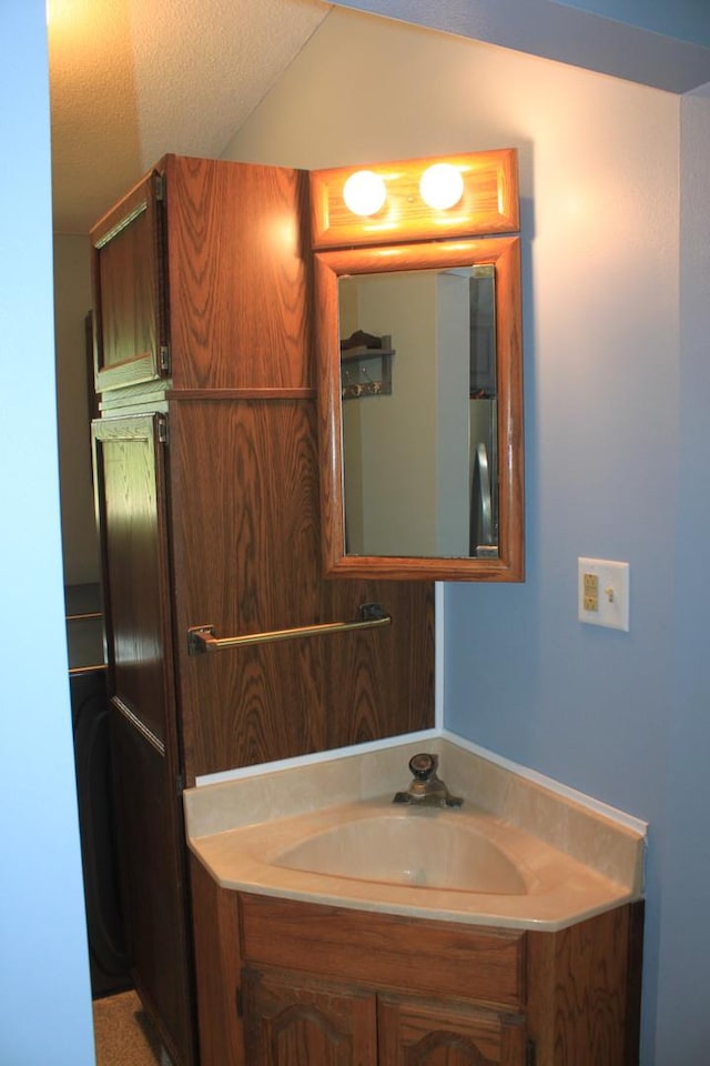 bathroom with vanity and lofted ceiling