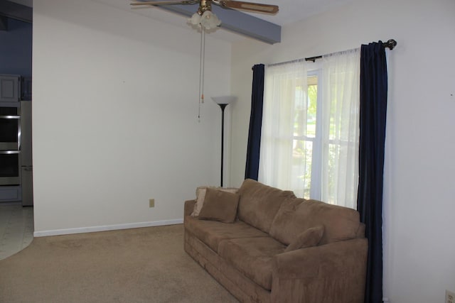 carpeted living room with ceiling fan and baseboards