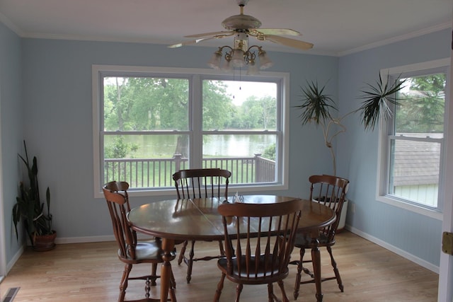 dining area with light wood finished floors, plenty of natural light, ceiling fan, baseboards, and crown molding