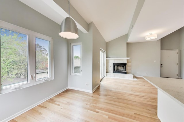 2136 W Evergreen Ave Unit 3B, Chicago, IL 60622 - unfurnished living room featuring vaulted ceiling, light wood finished floors, baseboards, and a fireplace