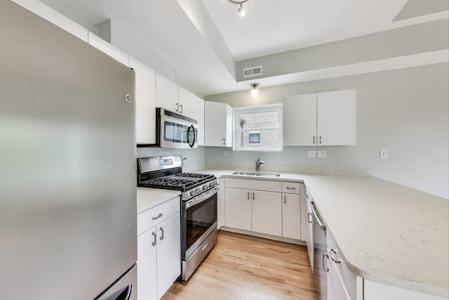 2136 W Evergreen Ave Unit 3B, Chicago, IL 60622 - kitchen with appliances with stainless steel finishes, a sink, light wood-type flooring, and white cabinets