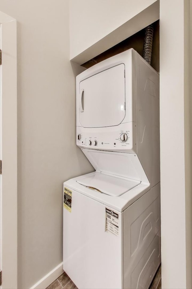 2136 W Evergreen Ave Unit 3B, Chicago, IL 60622 - laundry area featuring estacked washer and dryer, baseboards, and wood finished floors