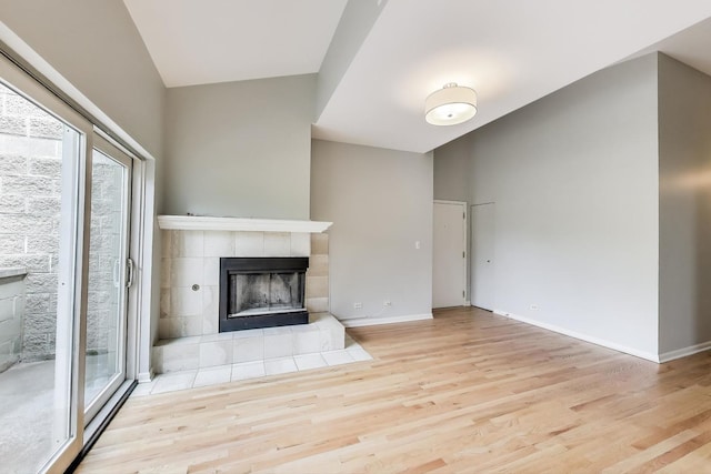 2136 W Evergreen Ave Unit 3B, Chicago, IL 60622 - unfurnished living room with a tiled fireplace, wood finished floors, and baseboards