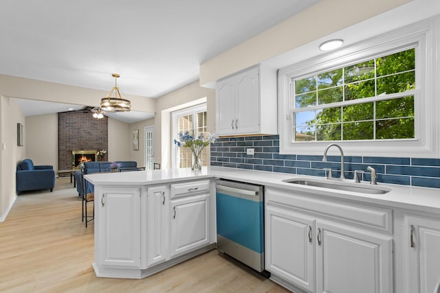 10S241 Wallace Dr, Downers Grove, IL 60516 - kitchen with dishwashing machine, a sink, a fireplace, light countertops, and backsplash