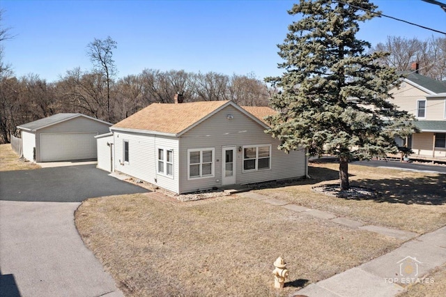 206 Walnut St, Cherry Valley, IL 61016 - view of front facade with a detached garage, an outbuilding, roof with shingles, and a chimney