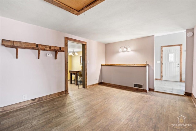 206 Walnut St, Cherry Valley, IL 61016 - unfurnished living room featuring wood finished floors and baseboards
