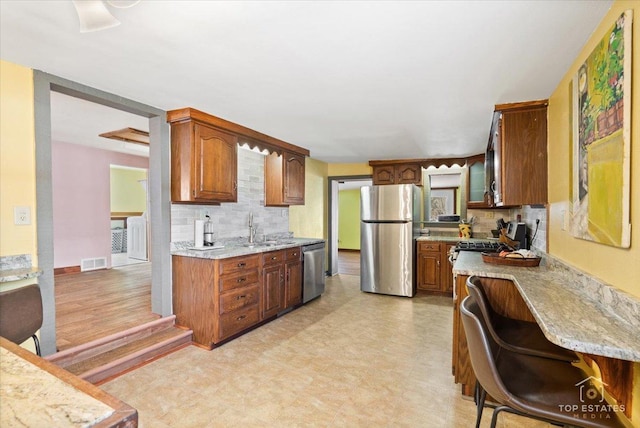 206 Walnut St, Cherry Valley, IL 61016 - kitchen featuring stainless steel appliances, a sink, tasteful backsplash, and light floors