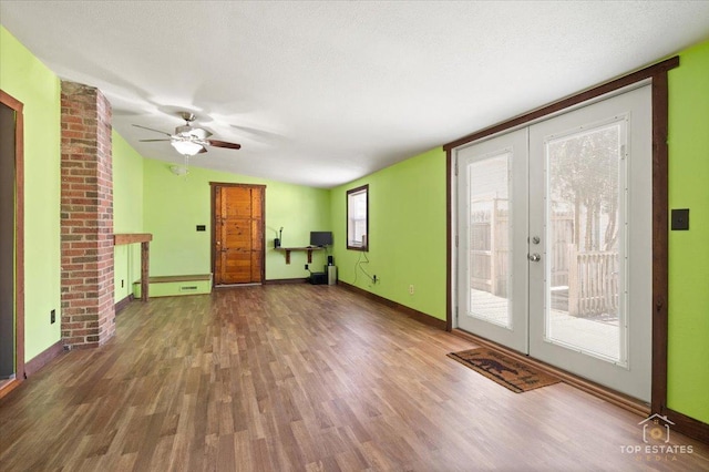 206 Walnut St, Cherry Valley, IL 61016 - unfurnished living room featuring french doors, wood finished floors, a ceiling fan, baseboards, and vaulted ceiling