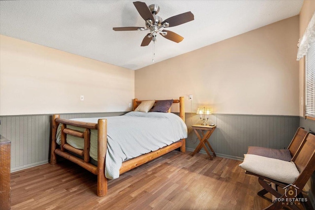 206 Walnut St, Cherry Valley, IL 61016 - bedroom with a wainscoted wall, wood finished floors, ceiling fan, and baseboards