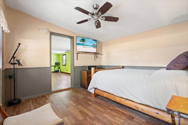 206 Walnut St, Cherry Valley, IL 61016 - bedroom with a wainscoted wall, lofted ceiling, wood finished floors, and a ceiling fan