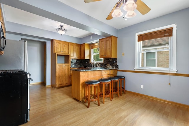 17708 Walter St, Lansing, IL 60438 - kitchen featuring range with gas cooktop, a peninsula, light wood-style floors, and freestanding refrigerator